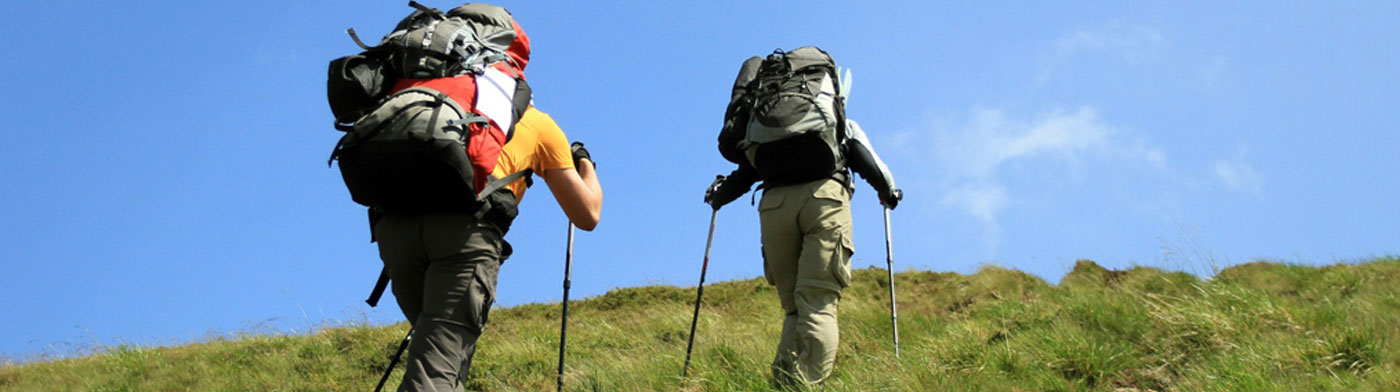 two hikers climbing a hill